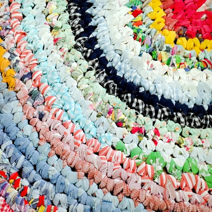 A colorful braided rag rug with various fabric strips